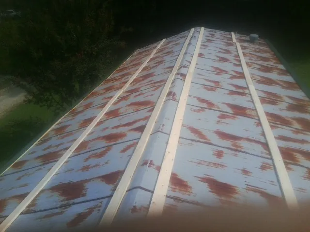 Rusted metal roof panels with new wood purlins before replacement — Storm Damage Roof Repair in Monarch by Roofing Brothers