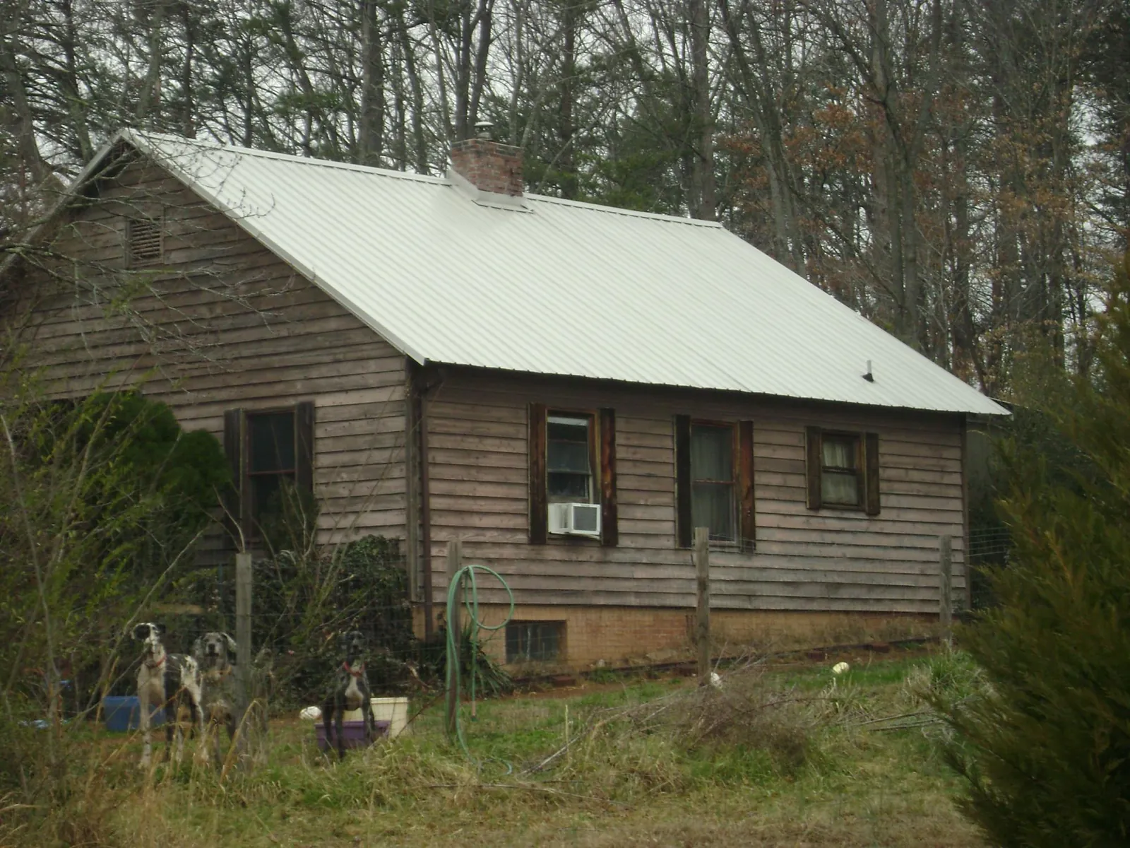 White metal roof on an old wood sided farmhouse, from a Metal Roof Installation job in Monarch